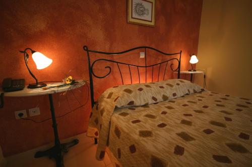 a bedroom with a bed and a table with a lamp at Efta Anemi - Benovias in Karfas