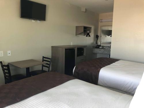 a hotel room with two beds and a table and a kitchen at Mariner Inn in Galveston