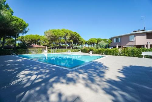 a swimming pool in front of a house at Villaggio Tivoli in Bibione