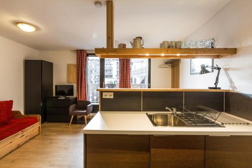 une cuisine avec un évier et un salon dans l'établissement Apartment Marcel - Cosy Chamonix Haven Mont Blanc, à Chamonix-Mont-Blanc