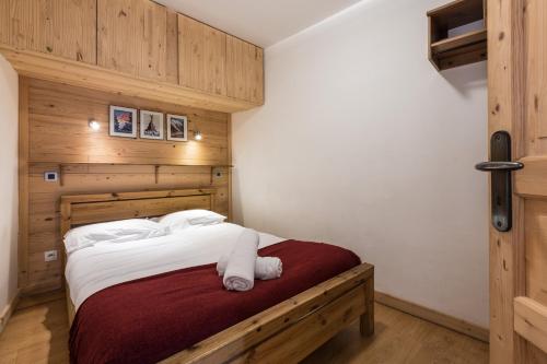 - une chambre avec un grand lit et des murs en bois dans l'établissement Apartment Marcel - Cosy Chamonix Haven Mont Blanc, à Chamonix-Mont-Blanc