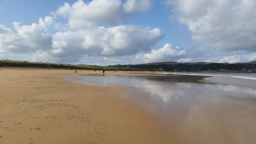 a beach with people walking on the sand at Crag Na Cor B&B in Culdaff