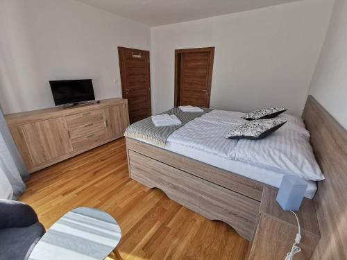 a bedroom with a bed and a flat screen tv at Zamoček in Matiašovce