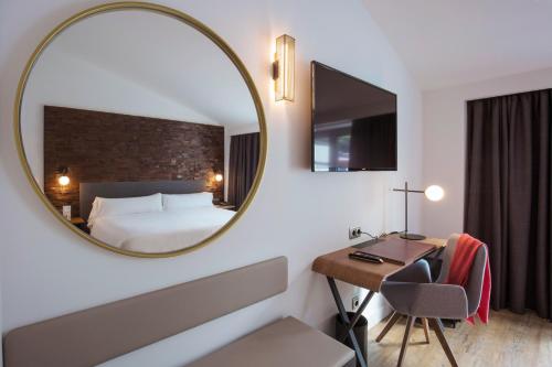 a room with a mirror, a table and a lamp at Yomo Centric in Andorra la Vella