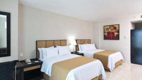 a hotel room with two beds and a television at Holiday Inn Express Ciudad Del Carmen by IHG in Ciudad del Carmen
