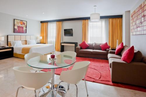 a hotel room with a bed and a table and chairs at Holiday Inn Express Ciudad Del Carmen by IHG in Ciudad del Carmen