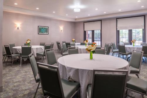 a banquet room with tables and chairs and flowers at Holiday Inn and Suites Addison by IHG in Addison