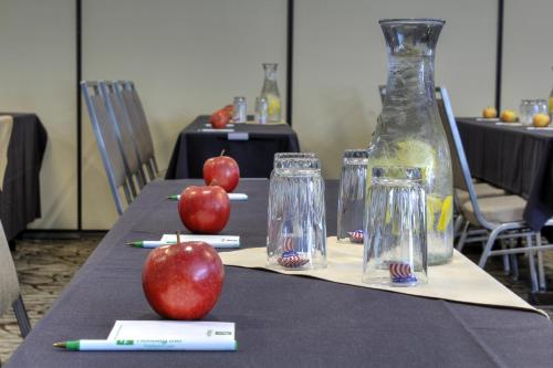 a table with apples and glasses on top of it at Holiday Inn Cody - Convention Center by IHG in Cody