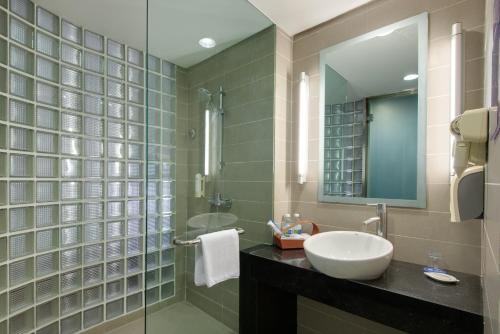 een badkamer met een wastafel en een spiegel bij Holiday Inn Express Gulou Chengdu, an IHG Hotel in Chengdu