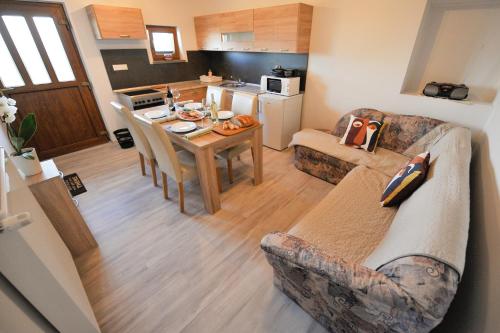 a living room and kitchen with a couch and a table at Apartments Jernej with Onsite Wellness in Brežice