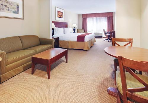a hotel room with a bed and a couch and a table at Holiday Inn Express Hotel & Suites Canton by IHG in Canton