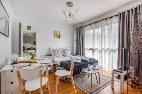 un salon avec un canapé, une table et des chaises dans l'établissement Lyon Confluence - duplex au calme avec parking privé en option, à Lyon