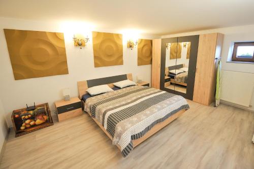 1 dormitorio con 1 cama grande y espejo grande en Apartments Jernej with Onsite Wellness, en Brežice