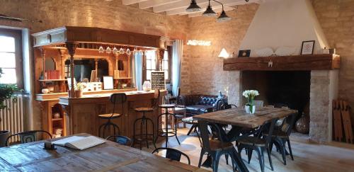 圖爾尼的住宿－B&B Des Histoires d'Anges - Côté Jardin，餐厅设有木桌、椅子和壁炉