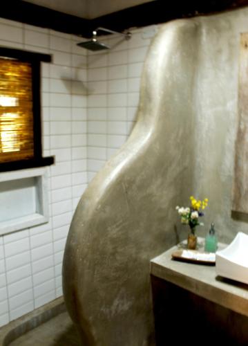 a bathroom with a large metal tub next to a sink at Pousada La Villa Caraiva in Caraíva
