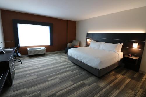 a hotel room with a bed and a television at Holiday Inn Express & Suites - Coffeyville by IHG in Coffeyville