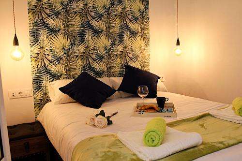 - un lit avec 2 serviettes et un verre de vin dans l'établissement WISH SUITE SAN LUIS DE SEVILLA, à Séville