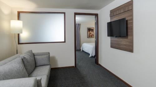 a living room with a couch and a flat screen tv at Holiday Inn Express Culiacan by IHG in Culiacán