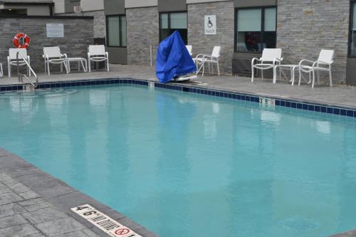 a large blue swimming pool with chairs and a blue tarp at Holiday Inn - Columbus, an IHG Hotel in Columbus