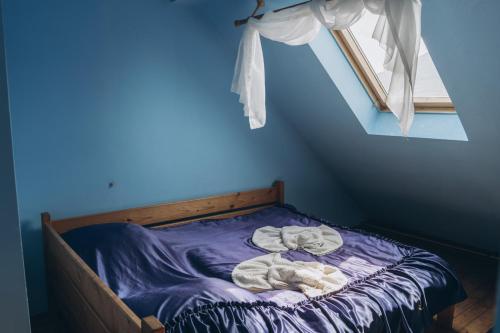 a blue bedroom with a bed with towels on it at Турянська долина in Perechin