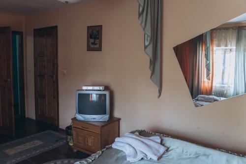 a living room with a tv and a bed at Турянська долина in Perechin