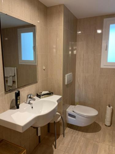 ein Badezimmer mit einem Waschbecken, einem WC und einem Spiegel in der Unterkunft Edificio C'an Patilla in Cala Ratjada