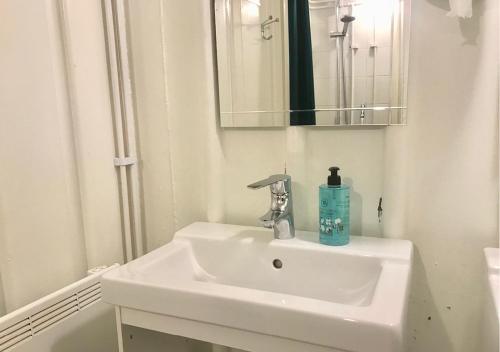 a white sink sitting under a mirror in a bathroom at Selmas Hytt och Salong in Uppsala