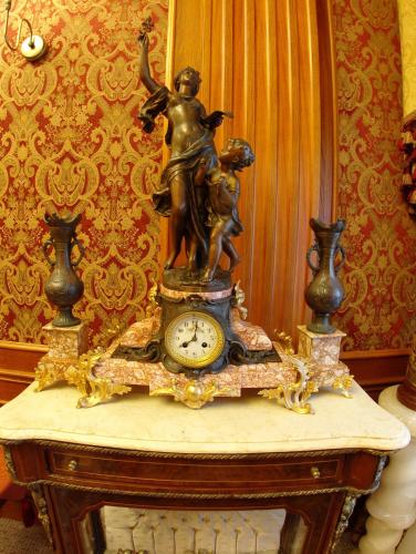 a statue of a woman on a table with a clock at Spa Hotel Gloria in Przemyśl