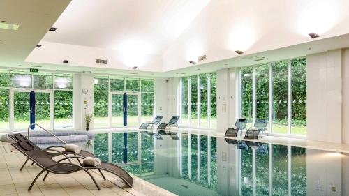 a living room with a pool and a chair at Muthu Clumber Park Hotel and Spa in Worksop