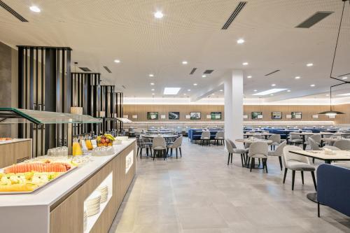 a restaurant with tables and chairs and a cafeteria at Acta Voraport in Barcelona