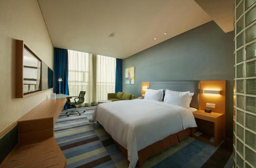 Säng eller sängar i ett rum på Holiday Inn Express Leshan City Square, an IHG Hotel