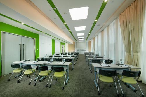 a classroom with tables and chairs in a room with green walls at Holiday Inn Express Leshan City Square by IHG High Speed Rail and Leshan Giant Buddha in Leshan