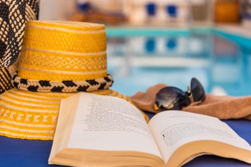 a hat and a book next to a swimming pool at Holiday Inn Express - Cartagena Bocagrande by IHG in Cartagena de Indias
