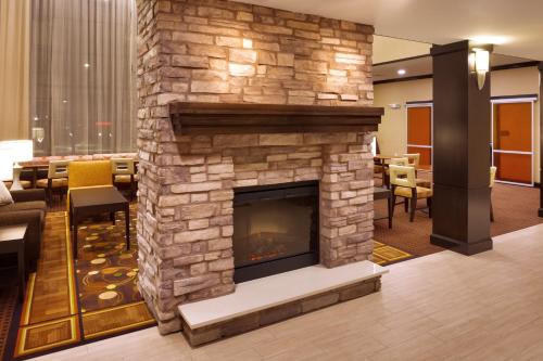 een stenen open haard in een hotellobby met stoelen bij Staybridge Suites Cheyenne, an IHG Hotel in Cheyenne