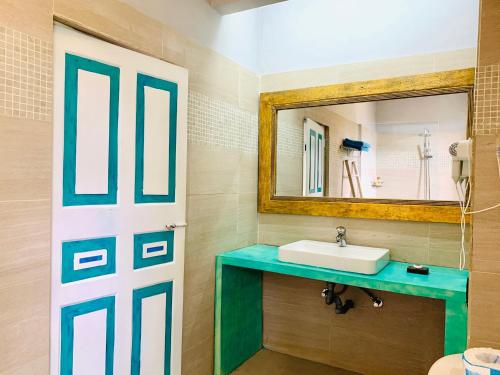 W łazience znajduje się umywalka i lustro. w obiekcie Thaproban Beach House w mieście Unawatuna
