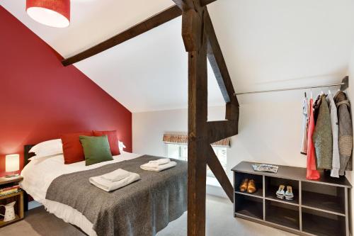 a bedroom with a bed and a red wall at The Old Sweet Factory in Harrogate