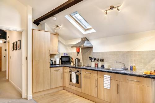 a kitchen with wooden cabinets and a skylight at The Old Sweet Factory in Harrogate