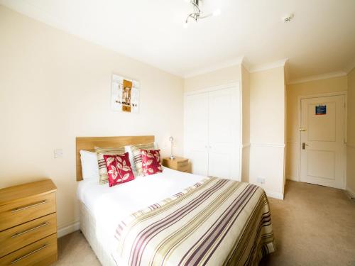ein Schlafzimmer mit einem großen weißen Bett mit roten Kissen in der Unterkunft OYO White Horse Lodge Hotel, East Thirsk in Thirsk