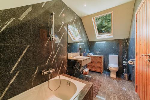 a bathroom with a tub and a sink at Villa Sol in Ponta do Sol