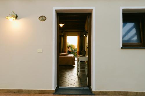 a hallway leading to a room with a bed and a clock at Hotel Barbagia in Dorgali