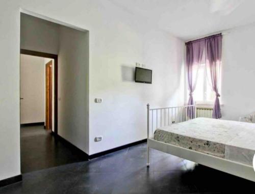 a white bedroom with a bed and a window at Dal Centurione in Rome