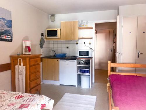 a small kitchen with a stove and a refrigerator at Boost Your Immo Les 2 Alpes Andromede 165 in Vénosc