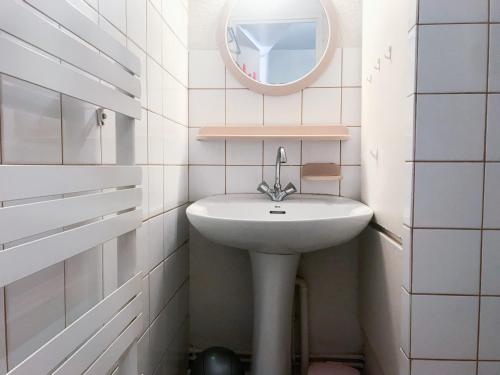 a white bathroom with a sink and a mirror at Boost Your Immo Les 2 Alpes Andromede 165 in Vénosc