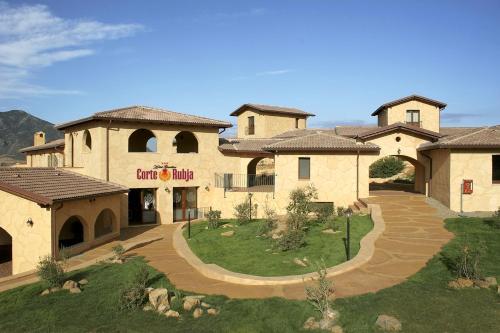 a large building with a walkway in front of it at Hotel Giardino Corte Rubja in Iglesias
