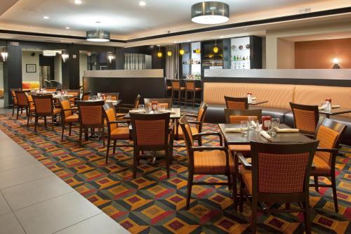 un restaurante con mesas y sillas en una alfombra en Holiday Inn Columbus-Hilliard, an IHG Hotel, en New Rome