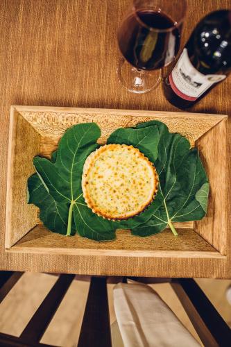 a wooden cutting board with a leaf and an orange at Hotel Barbagia in Dorgali
