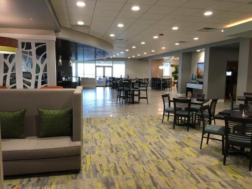 a lobby with tables and chairs and a restaurant at Holiday Inn Hotel & Suites Daytona Beach On The Ocean by IHG in Daytona Beach