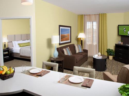 a hotel room with a living room with a bed at Candlewood Suites Atlanta West I-20 by IHG in Lithia Springs