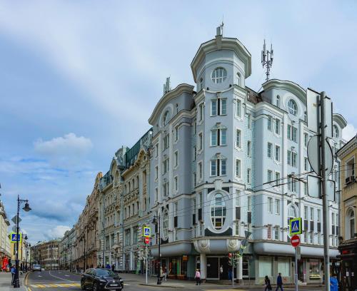 a large white building on the corner of a street at Lumiere Boutique Hotel in Moscow