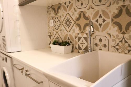 a kitchen with a white sink and a wall at Ocean Pearl Baleal in Ferrel